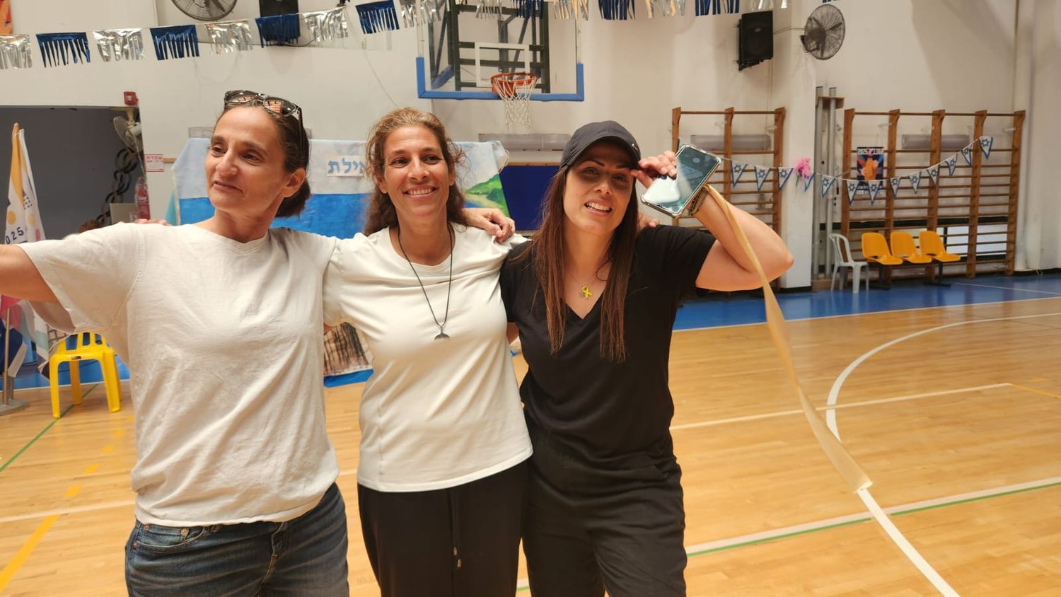 שלוש המורות והמתנדבות שמובילות את התוכנית, מחובקות באולם הספורט